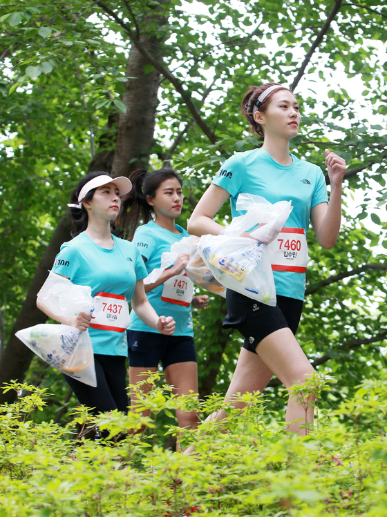 2019년 오프라인으로 진행된 ‘노스페이스 100 코리아’ 중 플로깅 이벤트 참가자들이 손에 쓰레기 봉투를 들고 달리는 모습. [사진 노스페이스]