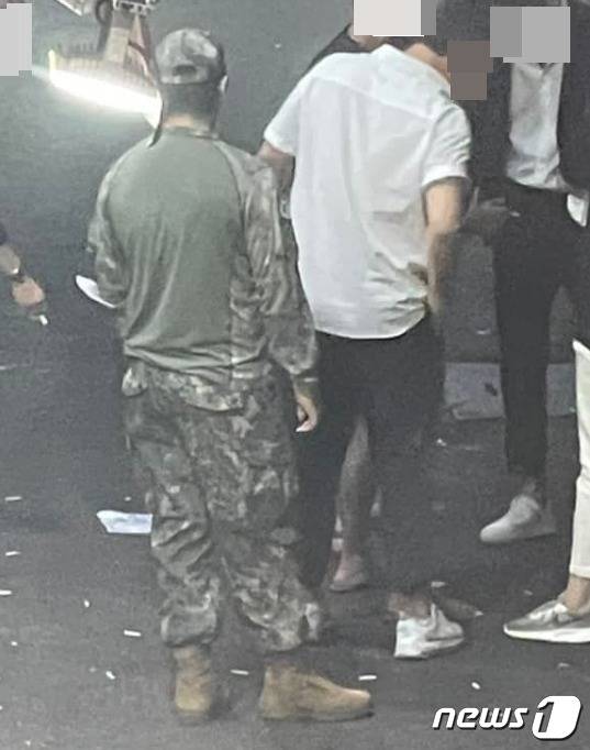 수원역 부근 맥주집 골목에서  컴뱃셔츠 차림으로 담배를 피우고 있는 병사. 컴뱃셔츠는 '작전 및 훈련'때만 착용할 수 있는 특수군복이기에 원칙적으로 외출 때 입고 나올 수 없다. (육대전 갈무리) ⓒ 뉴스1