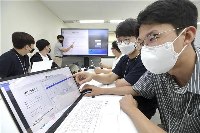 KT 직원들이 KT와 3S소프트가 공동 개발한 VDI 솔루션 화면을 바라보고 있다. VDI 솔루션은 본체 없이 가상의 PC를 활용해 물리적 공간 확보를 용이하게 만들어 주는 기술이다.KT 제공