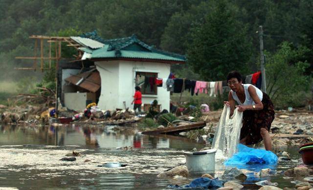 2002년 9월 2일 태풍 루사가 휩쓸고 간 강원 삼척시 미로면 계곡 반파된 집 앞에서 한 주민이 빨래를 하고 있다. 삼척=최흥수 기자