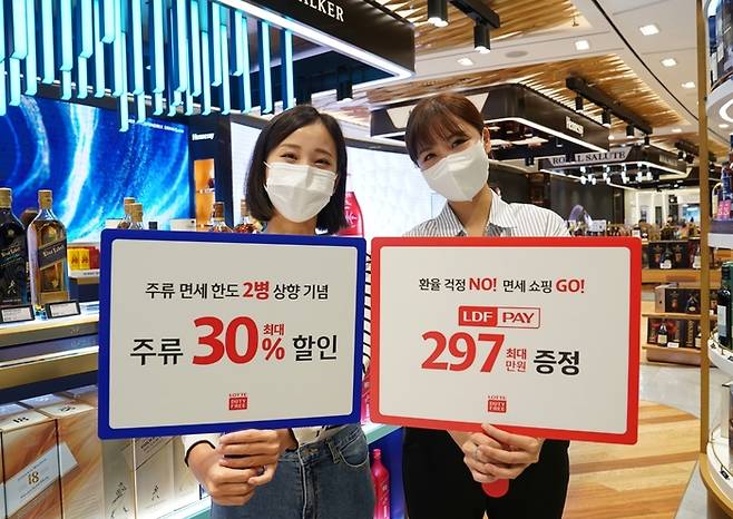 롯데면세점 모델들이 면세 한도 상향에 따른 행사를 알리고 있다. 롯데면세점 제공.