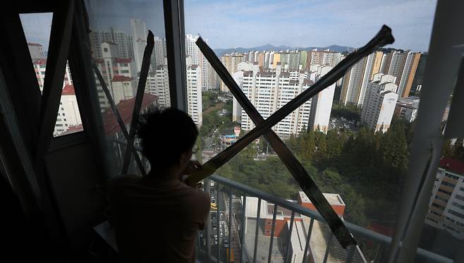 제11호 태풍 '힌남노'가 북상 중인 4일 경남 창원시 마산합포구 월영동 한 아파트에서 시민이 유리창에 테이프를 부착하고 있다. 마산합포구는 2003년 태풍 '매미' 때 큰 피해를 본 지역이다. Ⓒ연합뉴스