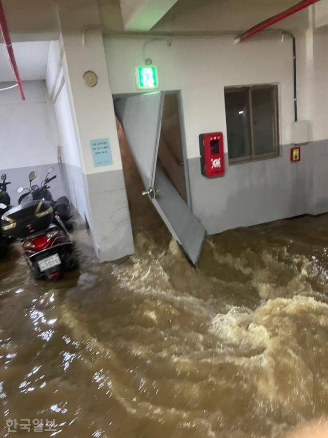 ③경북 포항 인덕동 아파트단지 지하주차장에 갑자기 많은 양의 빗물이 쏟아지면서 문이 휘어지고 있다.