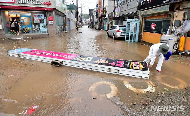 [포항=뉴시스] 이무열 기자 = 제11호 태풍 힌남노가 포항을 강타한 6일 오전 경북 포항시 구룡포읍에서 한 시민이 강풍에 쓰러진 간판을 옮기고 있다. 2022.09.06. lmy@newsis.com