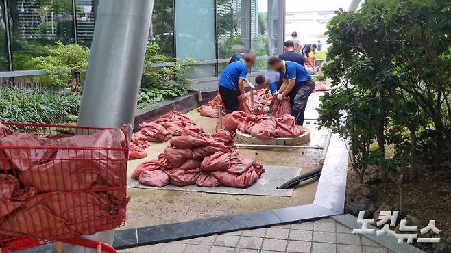 5일 부산 해운대구 마린시티의 한 아파트에서 제11호 태풍 힌남노 북상에 대비하기 위해 작업자들이 마대자루에 모래를 채워넣고 있다. 김혜민 수습기자