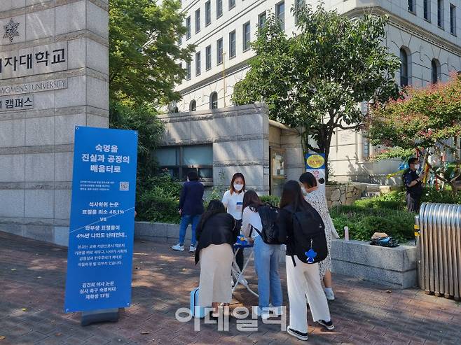 숙명여대 재학생들이 7일 오후 정문 앞에 세워진 ‘김건희 여사 숙명여대 석사학위 논문 표절 의혹에 대한 학교의 본조사 촉구’서명운동 가판에서 서명에 동참하고 있다. (사진=김형환 기자)