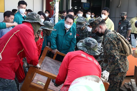 윤석열 대통령이 7일 오후 태풍 힌남노에 피해를 입은 경북 포항시 오천시장을 방문해 해병대원들과 쓰러진 가구를 옮기고 있다. 대통령실사진기자단