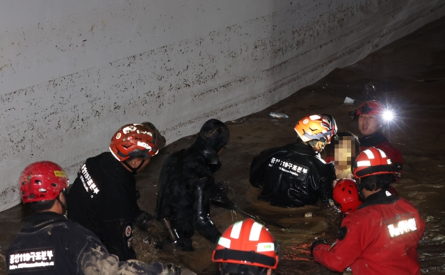 6일 저녁 태풍 '힌남노'의 폭우로 잠긴 경북 포항시 남구의 한 아파트 지하 주차장에서 소방·군 관계자들이 실종됐던 여성 주민을 구조하고 있다. 연합뉴스