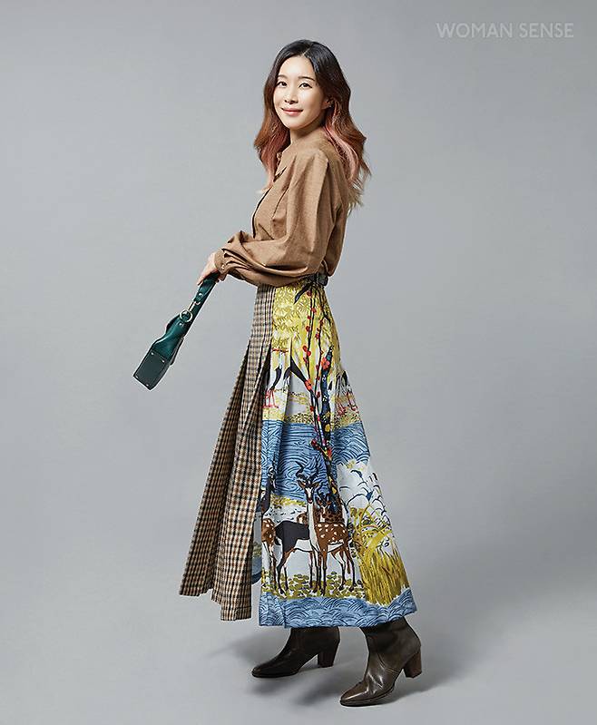 퍼프 숄더와 잘록한 허리 라인으로 여성스러움을 강조한 셔츠 13만8천원 모우트, 플라워 패턴이 믹스된 체크 주름 스커트 가격미정 위크엔드 막스마라, 청록색 호라이즌 바게트 백 35만8천원 랑카스터, 빈티지한 그레이 브라운 웨스턴 라인 부츠 25만8천원 렉켄.