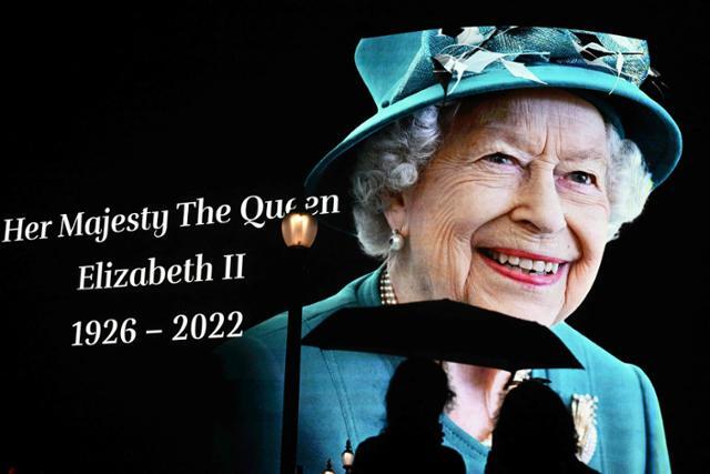 8일 영국 런던 중심가 피카디리서커스에서 시민들이 엘리자베스 2세 여왕을 기리는 현수막을 보고 있다. 런던=AFP 연합뉴스