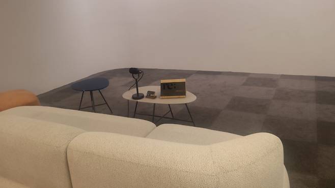 딥브레인AI의 '리메모리(Re;memory)' 전용 쇼룸. 정면을 포함해 좌, 우로 확장된 3면 스크린으로 시연된다. 앞에 대화가 가능한 마이크가 있다. /사진=김유경 기자