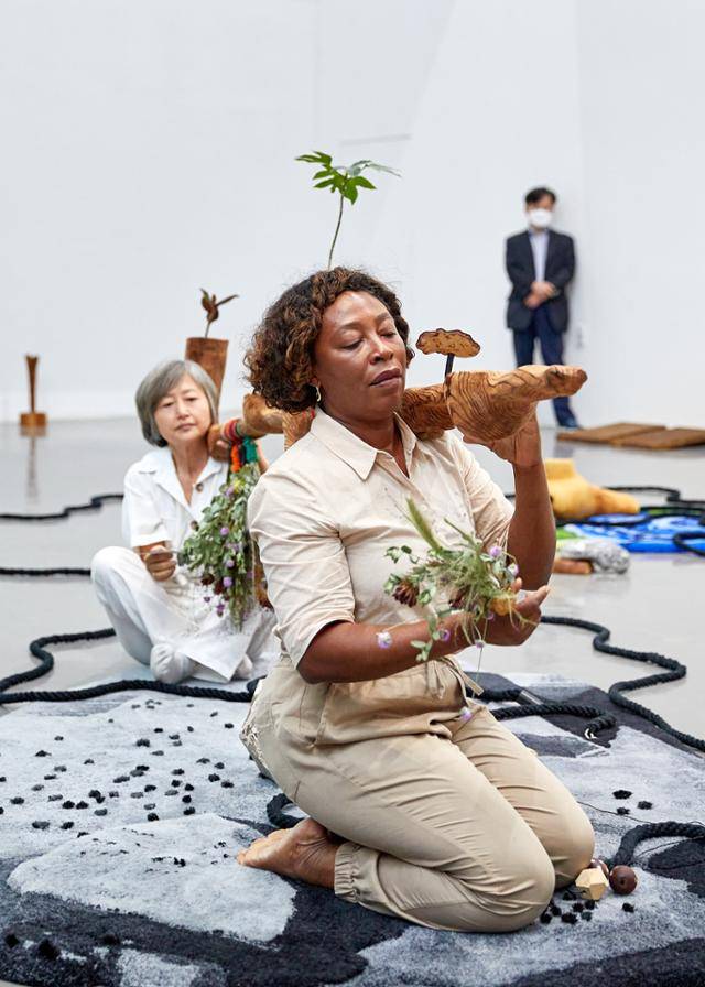 '2022부산비엔날레'에 참가한 나이지리아 출신 작가 오토봉 엥캉가가 전시장에서 퍼포먼스 '나즈막한 봉헌'을 펼치고 있다. 부산 비엔날레 제공