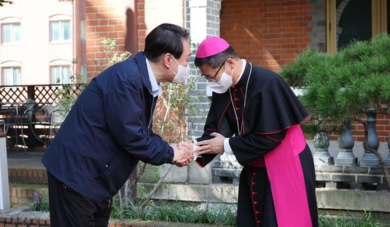 추석 연휴가 시작된 지난 9일 윤석열 대통령이 명동성당 무료급식소에서 배식봉사활동을 앞두고 정순택 대주교와 인사를 나누고 있다. 대통령실 사진기자단