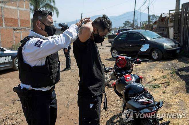 갱단 충돌 지역에서 몸 수색 하는 멕시코 군·경 [EPA 연합뉴스 자료사진. 재판매 및 DB 금지]