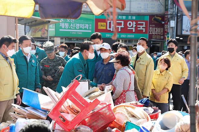 윤석열 대통령이 지난 7일 오후 제11호 태풍 힌남노로 피해를 입은 경북 포항시 남구 오천시장을 방문, 상인들을 위로하고 있다. [연합]