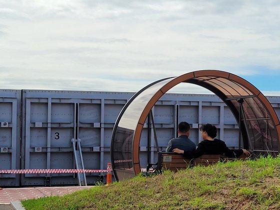 태풍 '힌남노'가 지나간 직후인 지난 6일 오전 10시쯤 경남 창원시 마산합포구 마산구항 방재언덕에 조성된 공원에서 산책을 즐기는 중년부부 앞에 차수벽(기립식 방조벽)이 세워져 있다. 안대훈 기자