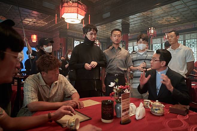 Yoon Jong-bin (center) speaks with the cast and crew of "Narco-Saints." (Netflix)