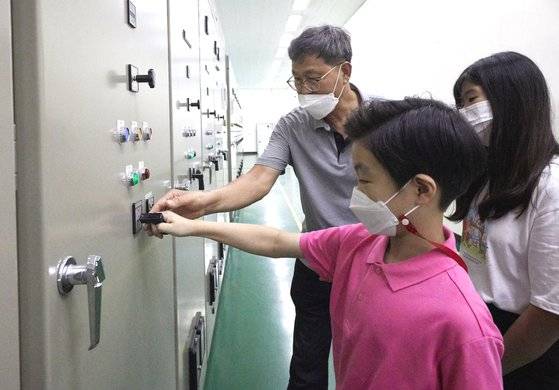 이철희(왼쪽) 주임이 소중 학생기자단에게 모터 펌프를 수동으로 작동하는 법을 알려주고 있다.