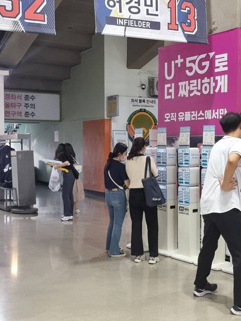 야구팬들이 서울 송파구 잠실야구장에 설치된 보조배터리 대여 서비스 ‘충전돼지’를 사용하고 있다. {㈜백퍼센트]