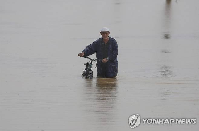 침수된 도로, 자전거 끌고 쓸쓸히 (토아바하 EPA=연합뉴스) 19일(현지시간) 푸에르토리코 토아바하에서 한 시민이 허리케인 '피오나' 영향으로 침수된 도로를 자전거를 끌고 지나가고 있다. 2022.9.20