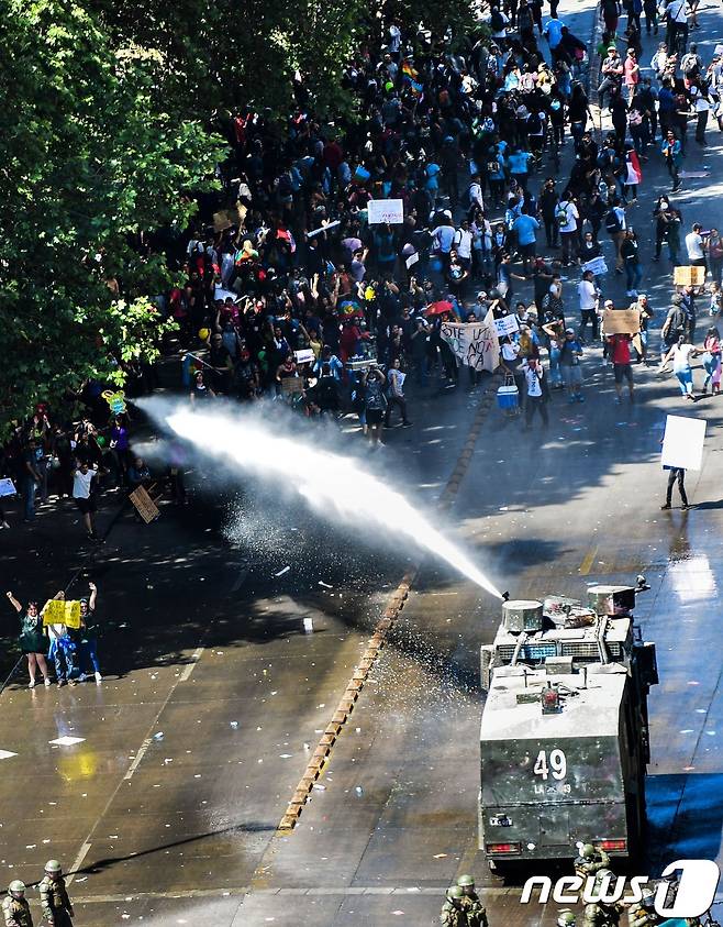 2019년 10월 31일(현지시간) 칠레 산티아고에서 '지하철 요금 인상'으로 촉발된 반정부 시위가 격화되고 있는 가운데 경찰이 시위대를 향해 물대포를 발사하고 있다. 칠레 정부는 시위가 확산되자 APEC 정상회의와 12월 유엔 기후변화협약 당사국 총회 개최를 취소했다. ⓒ AFP=뉴스1 ⓒ News1 우동명 기자