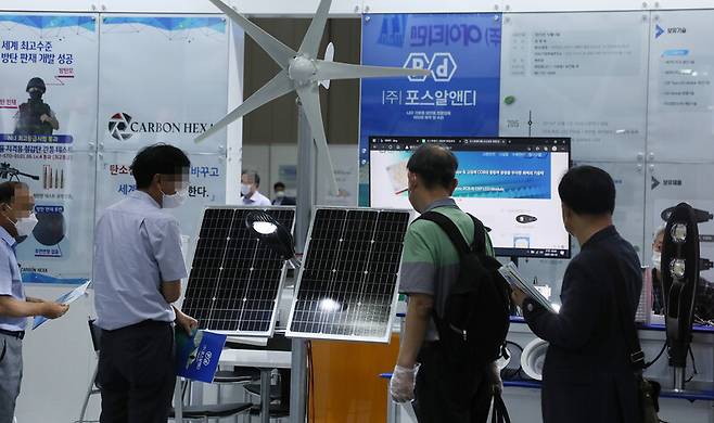 지난해 경기도 고양시 킨텍스 제1전시장에서 열린 ‘2021 세계 태양에너지 엑스포'에서 참가자들이 태양광 관련 제품들을 둘러보고 있다. 연합뉴스