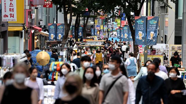 20일 오후 서울 명동거리에서 마스크를 쓴 시민 및 관광객들이 걸어가고 있다. 현재 50인 이상의 행사·집회 등 밀집도가 높은 야외 장소에서는 마스크 착용 의무가 유지되고 있다. 연합뉴스