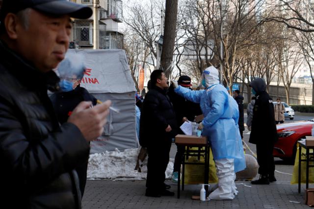 지난 1월 25일 한 중국 남성이 베이징 펑타이구의 코로나19 검사소 앞에서 담배를 피우고 있다. 베이징=로이터 연합뉴스