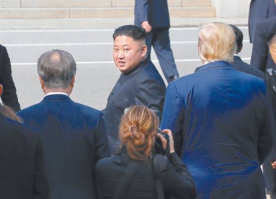 2019년 6월 30일 북한 김정은 국무위원장이 판문점에서 문재인 당시 대통령과 도널드 트럼프 미국 대통령의 배웅을 받으며 군사분계선을 넘어 북측으로 돌아가다 뒤돌아보고 있다. 연합뉴스