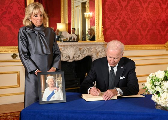 조 바이든 미국 대통령이 현지 시간으로 18일 런던 랭커스터 하우스에서 엘리자베스 2세 여왕을 애도하는 조문록을 작성하고 있다. 왼쪽은 질 바이든 영부인. 로이터=연합뉴스