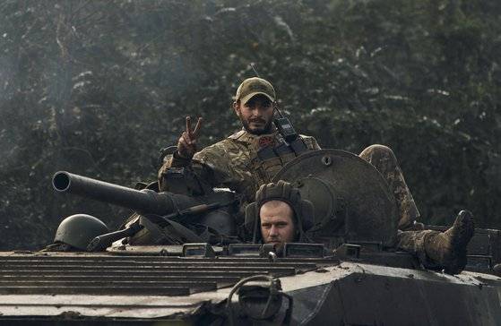 러시아가 점령했던 우크라이나 북동부 하르키우 인근의 전략적 요충지인 이지움을 수복한 우크라이나 군인이 13일 BMP-2 보병전투차를 타고 승리의 V자를 보이고 있다. [AP=연합뉴스]