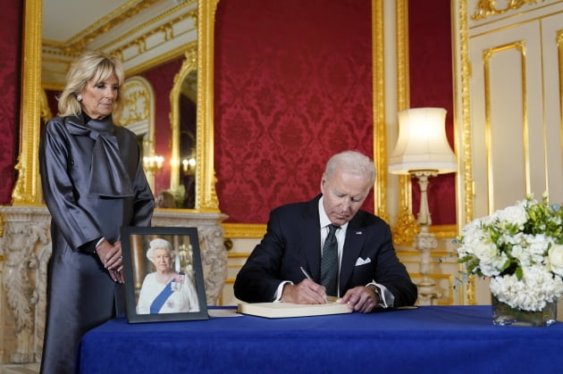 조 바이든 미국 대통령이 18일(현지 시각) 런던 랭커스터 하우스에서 엘리자베스 2세 여왕을 애도하는 조문록을 작성하고 있다. 왼쪽은 질 바이든 영부인. /로이터=연합뉴스