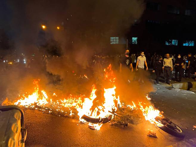 이란 테헤란에서 지난 19일(현지시간) 마흐사 아미니의 죽음에 항거하는 시위대가 경찰 오토바이를 불태우고 있다. 로이터연합뉴스
