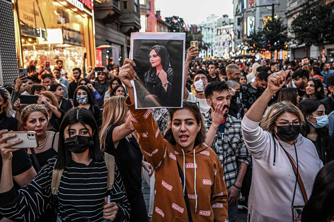 20일 튀르키예(터키) 이스탄불 이스티클랄 거리에서 시위대가 히잡을 제대로 쓰지 않았다는 이유로 경찰에 체포된 뒤 의문사한 이란 여성 마흐사 아미니(22)의 사진을 들고 이란 정부에 진상 규명을 촉구하고 있다. 아미니는 이란 서부 쿠르드족 거주지 사케즈 출신으로, 사망 소식이 전해진 뒤 전 세계 쿠르드족을 중심으로 항의 시위가 커지고 있다.    AFP 연합뉴스