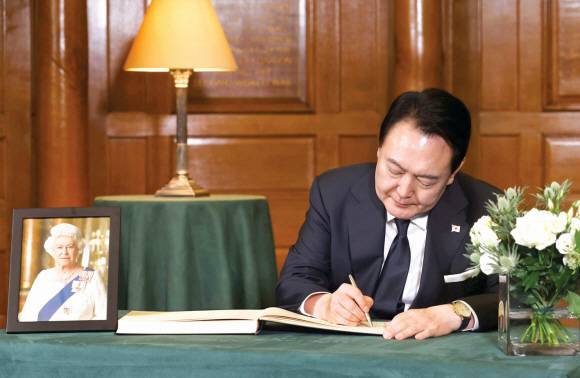 윤석열 대통령이 19일 영국 런던 웨스트민스터 사원에서 엄수된 엘리자베스 2세 여왕 장례식에 참석한 뒤 조문록을 작성하고 있다. 영국 외교부 플리커 계정·연합뉴스