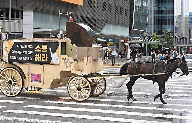 지난 13일 카카오게임즈 사옥이 입주해 있는 경기 성남시 판교역 일대에서 일부 우마무스메 게임 이용자들이 마차를 동원해 시위를 벌이고 있다. /뉴스1