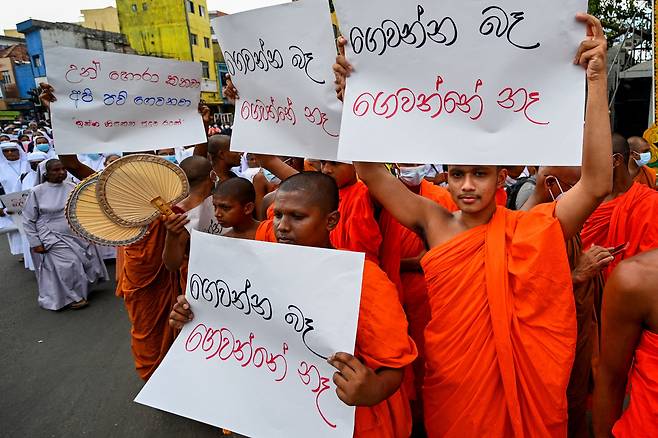 20일(현지 시각) 스리랑카 수도 콜롬보 시내에서 불교 승려들이 가톨릭 수녀들(왼쪽 뒤)과 함께 전기요금 급등에 항의하며 반정부 시위를 벌이고 있다.