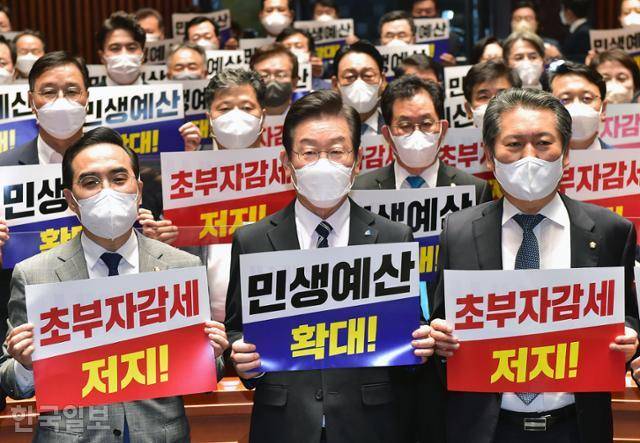 이재명(앞줄 가운데) 더불어민주당 대표와 박홍근(왼쪽) 원내대표 등 민주당 의원들이 22일 국회에서 열린 의원총회에서 '초부자감세 저지', '민생예산 확대' 등의 손팻말을 들고 구호를 외치고 있다. 오대근 기자