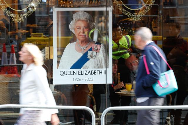 지난 18일 오후(현지시간) 영국 런던 트라팔가 광장 인근 식당에 엘리자베스 2세 여왕 사진이 걸려 있다. 이베트 쿠퍼는 코로나19 유행으로 영국에 전례 없는 봉쇄 조치가 내려진 상황에서 국민을 안정시키는 연설은 여왕만이 할 수 있었다고 설명했다. 뉴스1