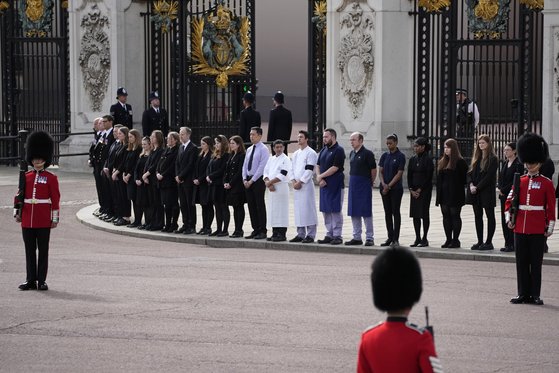 버킹엄궁의 직원들이 19일 엘리자베스 여왕 장례식에서 줄을 맞춰 애도를 표하고 있다. AP=연합뉴스