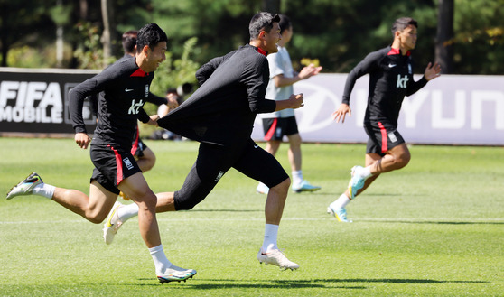 Son Heung-min, left, and Kim Min-jae train together at the National Football Training Center in Paju, Gyeonggi on Wednesday. [YONHAP]