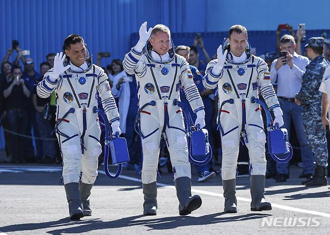 [AP/뉴시스] 국제우주정거장(ISS)에서 임무를 수행할 미국인 프랭크 루비오(왼쪽)와 러시아의 세르게이 프로코피예프(가운데), 드미트리 페텔린 등 우주비행사 3명이 21일(현지시간) 카자흐스탄 바이코누르 우주센터에서 취재진을 향해 인사하고 있다. 2022.09.22