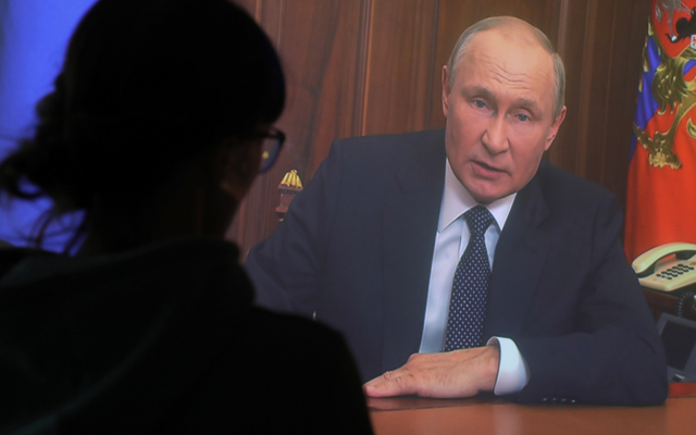 21일(현지시간) 러시아 수도 모스크바에서 한 여성이 블라디미르 푸틴 러시아 대통령의 대국민 연설을 TV 화면으로 지켜보고 있다. EPA연합뉴스