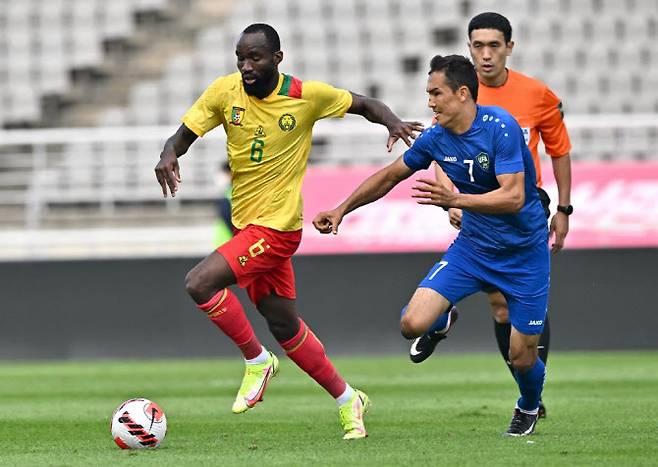 카메룬의 모우미 브라이스 은가말레우(왼쪽)가 우즈베이스틴의 오타벡 슈쿠로프를 제치고 공을 드리블 하고 있다. 사진=AFPBBNews