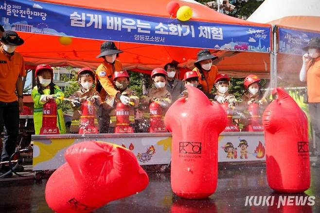 23일 오후 서울 여의도공원 문화의 마당에서 열린 2022 서울안전한마당을 찾은 어린이들이 소화기 체험을 하고 있다.
