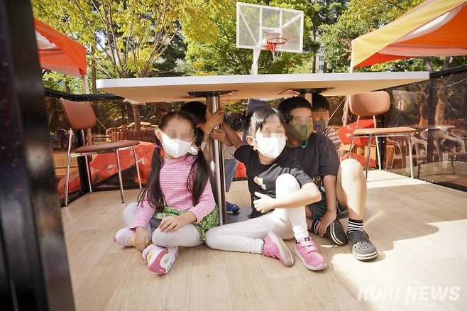 23일 오후 서울 여의도공원 문화의 마당에서 열린 2022 서울안전한마당을 찾은 어린이들이 지진체험 부스에서 지진 대피 체험을 하고 있다.