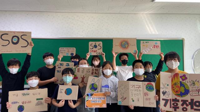 23일 강원도 강릉시 청소년마을학교 '날다' 학생들이 기후정의행진 참여를 위해 만든 피켓을 들고 있다. '날다' 제공