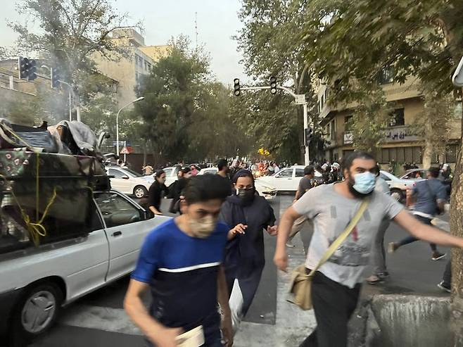 [테헤란=AP/뉴시스] 19일(현지시간) 이란 테헤란 시내에서 복장 규정 위반으로 구금됐던 여성이 숨진 것에 항의하는 시위대가 경찰을 피해 달아나고 있다. 지난 13일 테헤란에서 히잡을 쓰지 않았다는 이유로 경찰에 체포된 20대 여성이 16일 경찰 조사 중 숨지자 이에 대한 진상 규명을 촉구하는 항의 시위가 잇따르고 있다. 이란 경찰은 해당 여성이 심장마비 증상을 보였다고 밝혔으나 유족은 고인이 심장 관련 질환을 앓은 적이 없다고 반박했다. 2022.09.20.