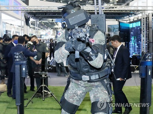 지난 21일 경기도 고양시 킨텍스 제2전시장에서 열린 대한민국 방위산업전시회(DX KOREA 2022)에서 해외 군 관계자들이 완전무장한 한국군 전투사격 훈련을 보고 있다. <연합뉴스>