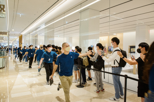 24일 오픈한 '애플 잠실'에서 스토어 팀원들이 하이파이브로 고객을 환영하고 있다. 애플 제공